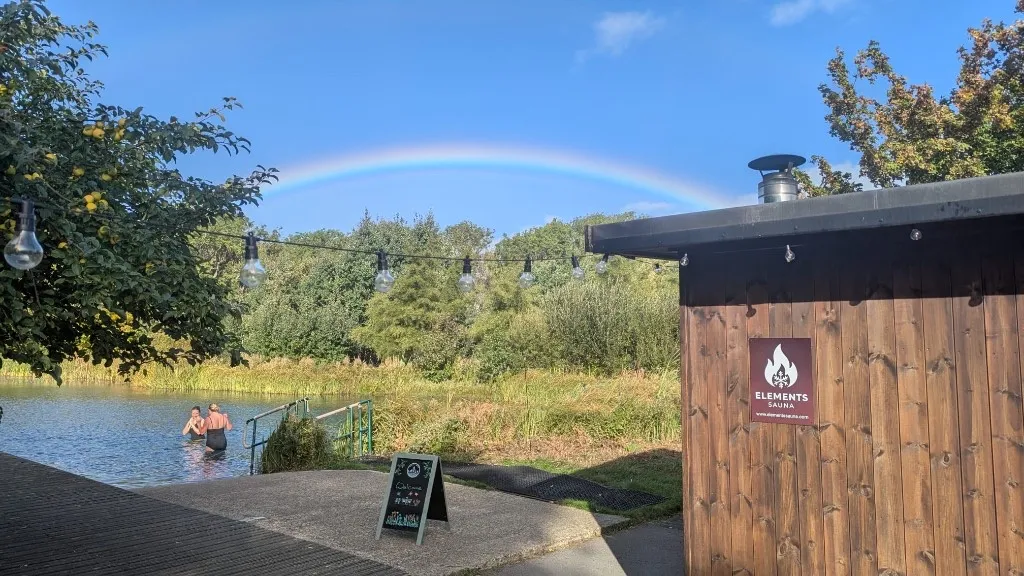 A rainbow over the lake behind the sauna